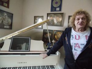 Piano Man: Robins with his gold albums and grand piano. (Photo/Local Spins)