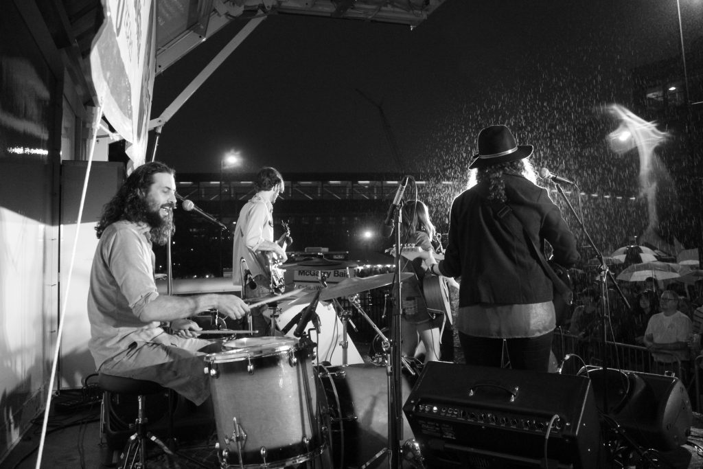 The Rain Wives: The Grand Rapids folk-rock band and its fans reveled in the rain Saturday for the Local First Street Part. (Photo/Anna Sink) 