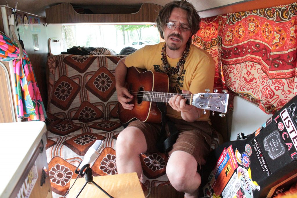 VW Bus Life: Nicholas James Thomasma performing inside his classic vehicle. (Photo/Anna Sink)