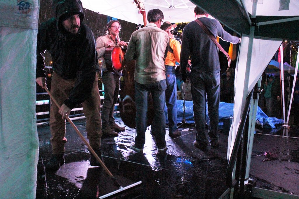 Squeegee Fest: Organizer Quinn Mathews clears water from the Blue Bridge stage on Saturday. (Photo/Anna Sink)